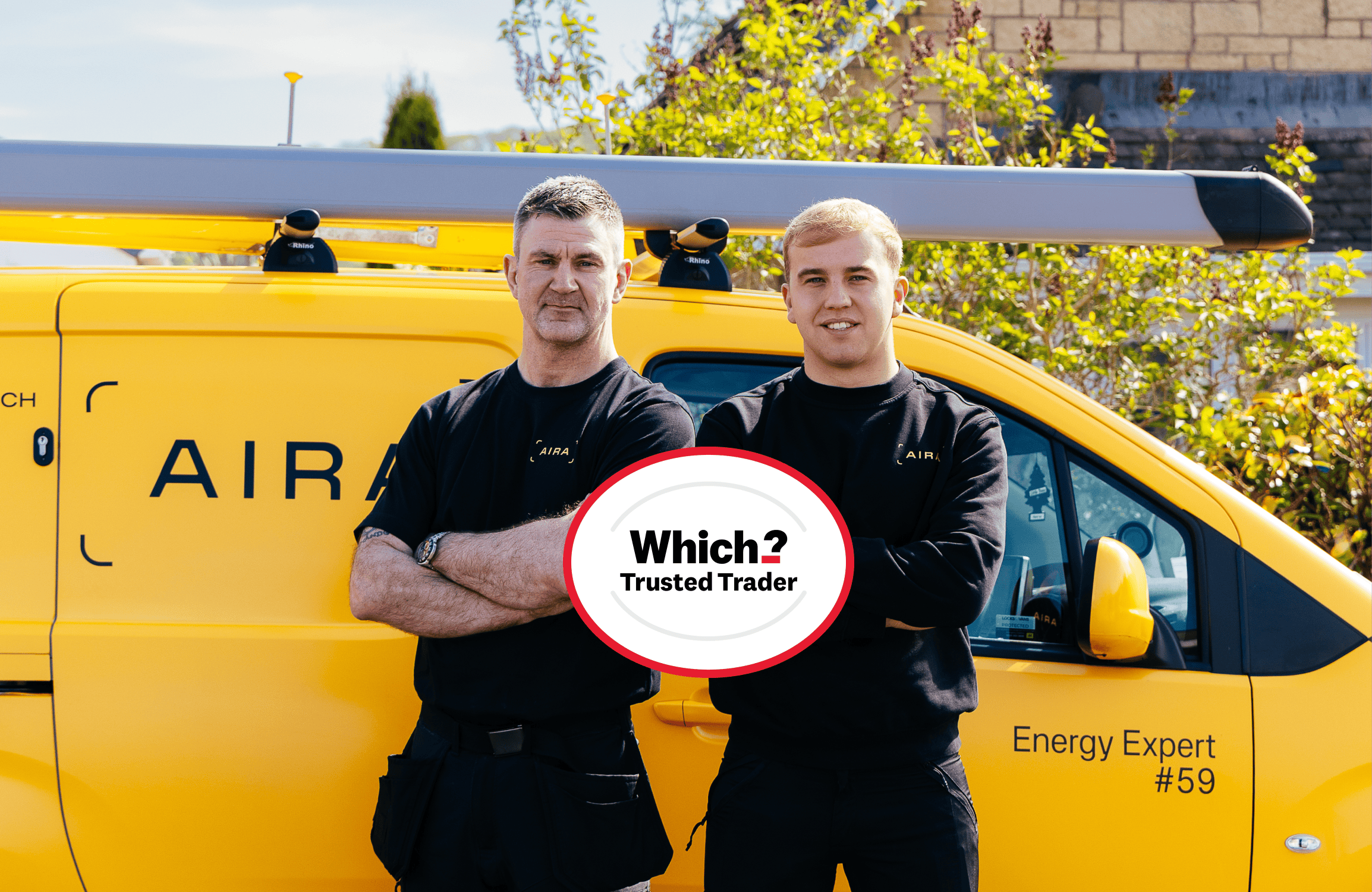 Two Aira Heat Pump installers arms folded looking at camera which Which? Trusted Trader logo in front of them